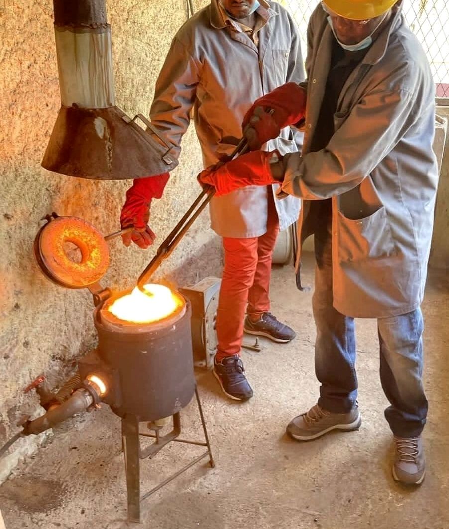 Operators handling molten metal during a controlled pour